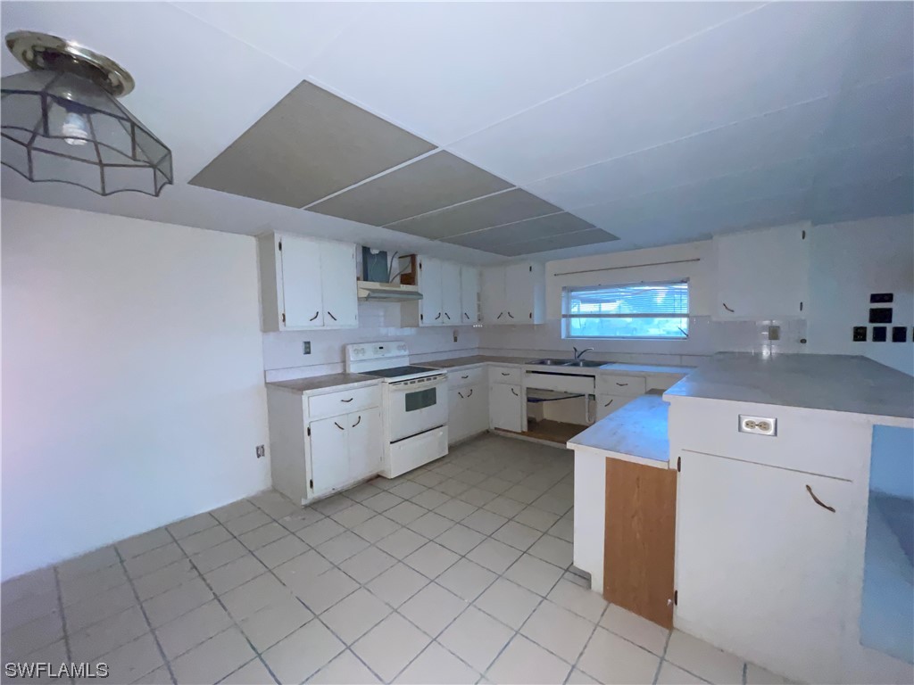 1107 Patterson Road Cape Coral, FL 33909 - Photo 6 of 35 a kitchen that has a sink and a stove in it