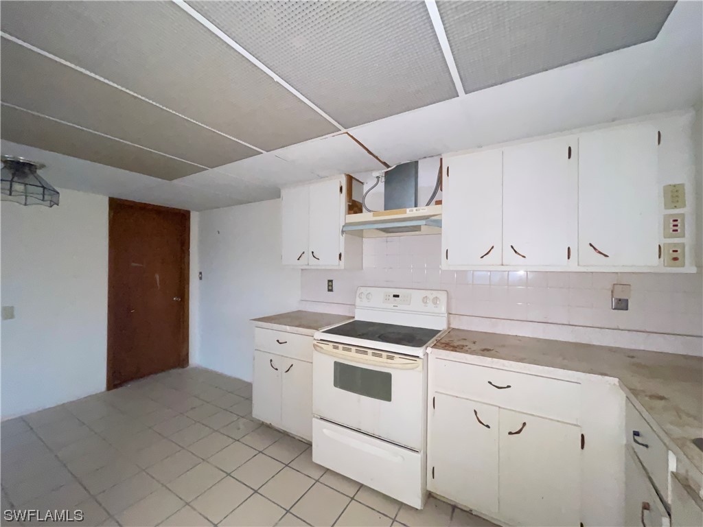 1107 Patterson Road Cape Coral, FL 33909 - Photo 8 of 35 a kitchen with white cabinets and white appliances