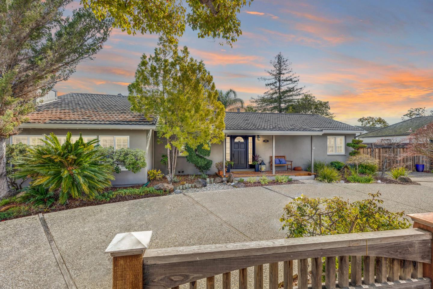 front view of house with a yard and potted plants