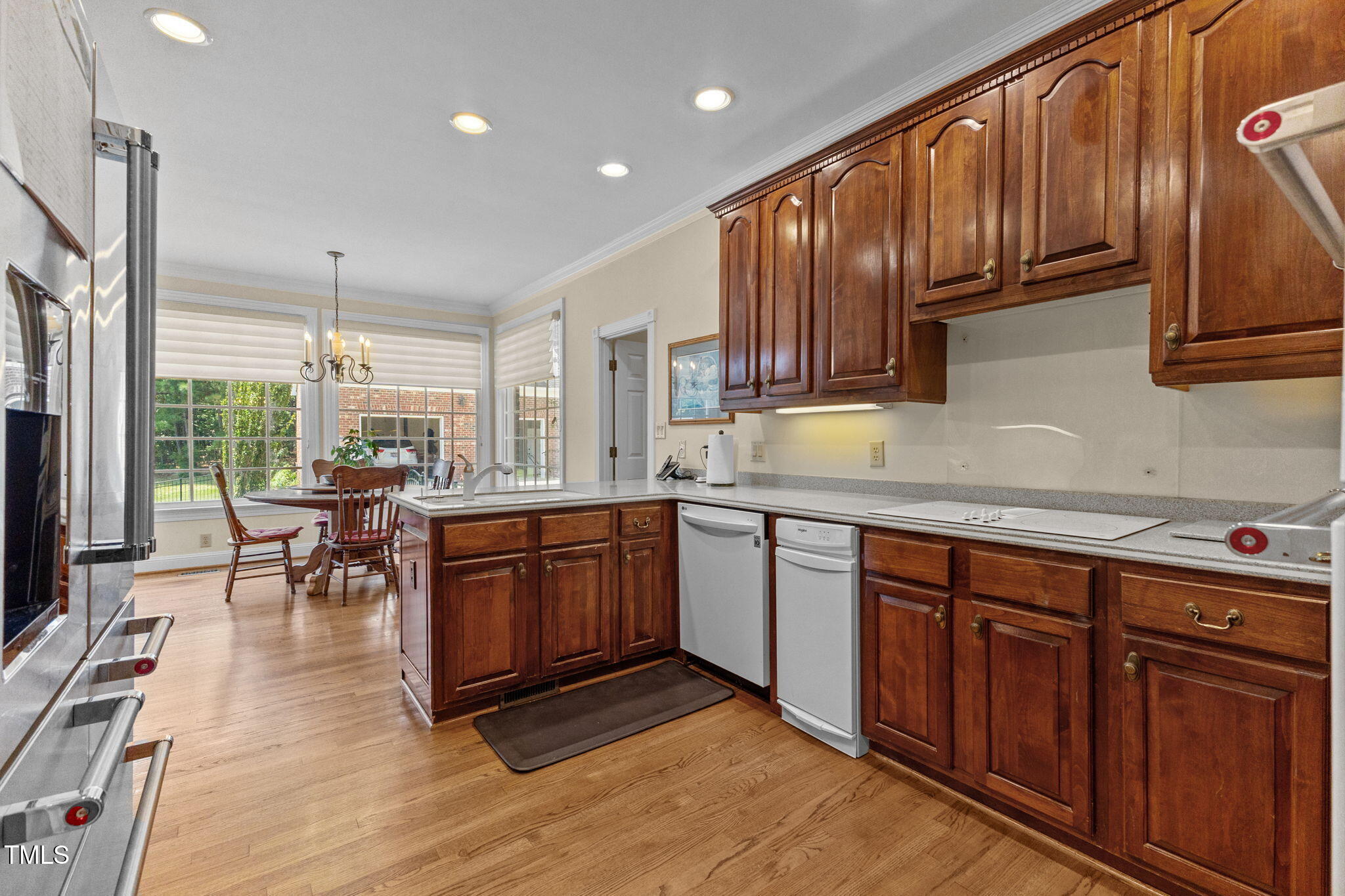 5405 Carbonton Road Sanford, NC 27330 - Photo 19 of 63 a kitchen with stainless steel appliances granite countertop wooden cabinets a stove a sink and a dining table with wooden floor