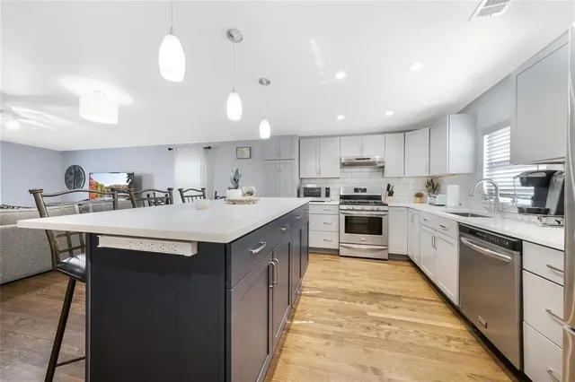 a kitchen with granite countertop white cabinets and white appliances