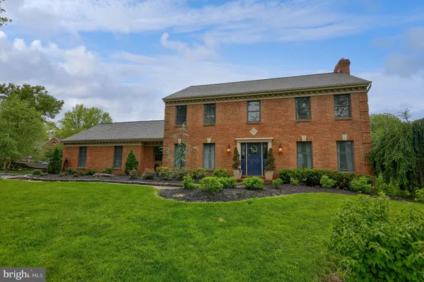 a front view of a house with a yard and trees