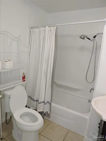 a white toilet sitting next to a bath tub