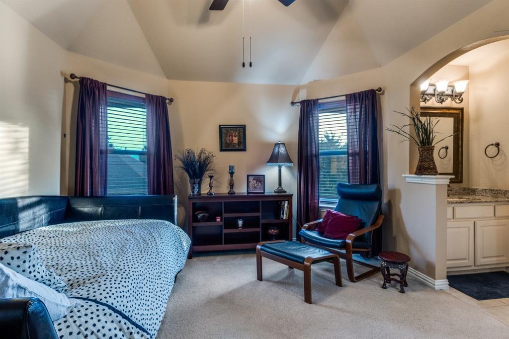 2810 Baker Street Sachse, TX 75048 - Photo 21 of 26 Bedroom featuring lofted ceiling, light colored carpet, multiple windows, arched walkways, and ceiling fan