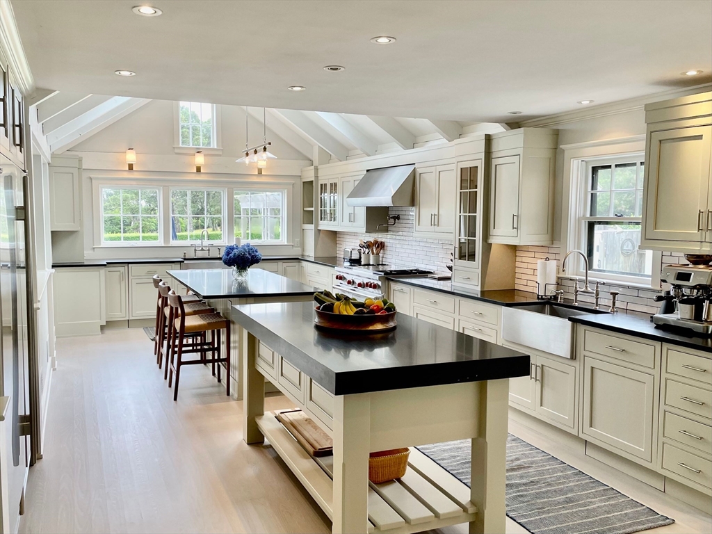 1 Pochick Avenue Nantucket, MA 02554 - Photo 12 of 42 a kitchen with stainless steel appliances granite countertop a stove a sink dishwasher a dining table and chairs with wooden floor