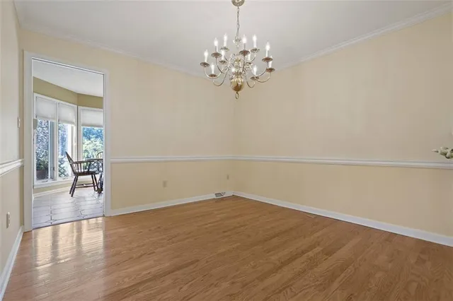 a view of a room with wooden floor and chandelier