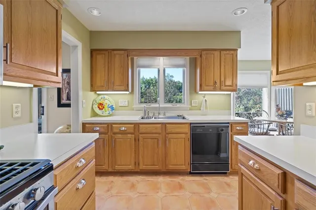 a kitchen with stainless steel appliances granite countertop a sink stove and cabinets