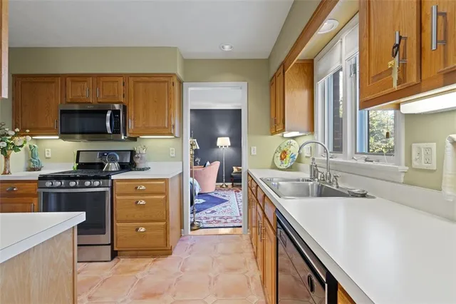 a large kitchen with stainless steel appliances granite countertop a sink and a stove