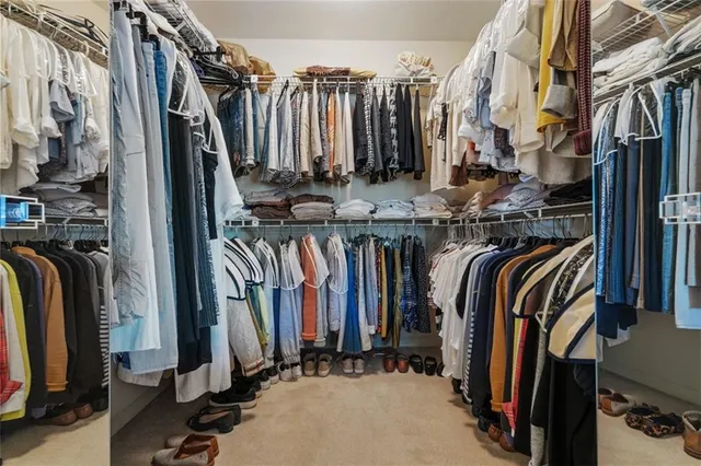 a view of walk in closet with clothes