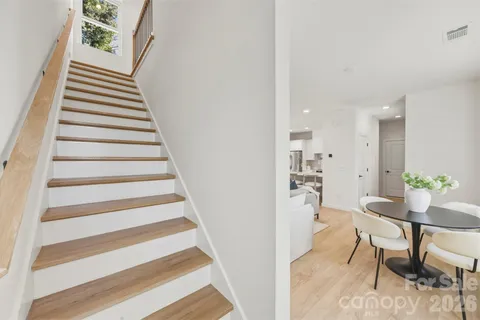 a view of a hallway with wooden floor and a dining room