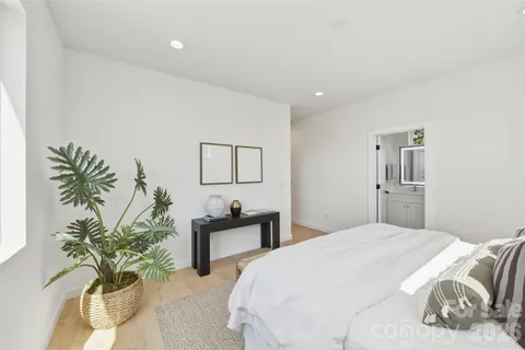 a bedroom with a large bed and a potted plant