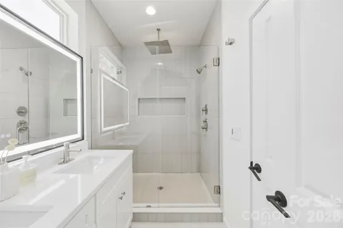 a bathroom with a bathtub shower sink vanity granite and shower