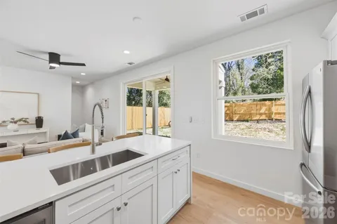 a kitchen with stainless steel appliances granite countertop a sink and a large window
