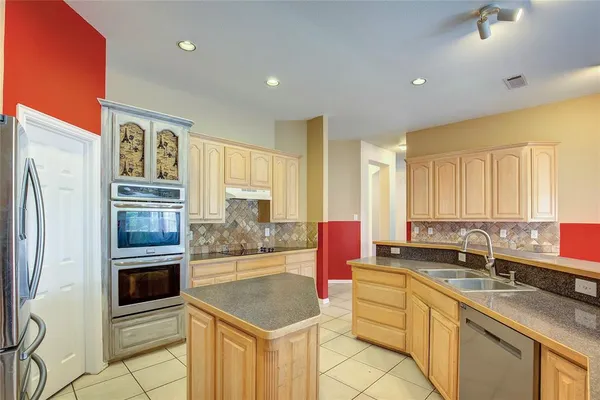 a kitchen with stainless steel appliances a sink stove and refrigerator