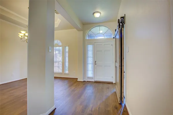 an empty room with wooden floor and mirror