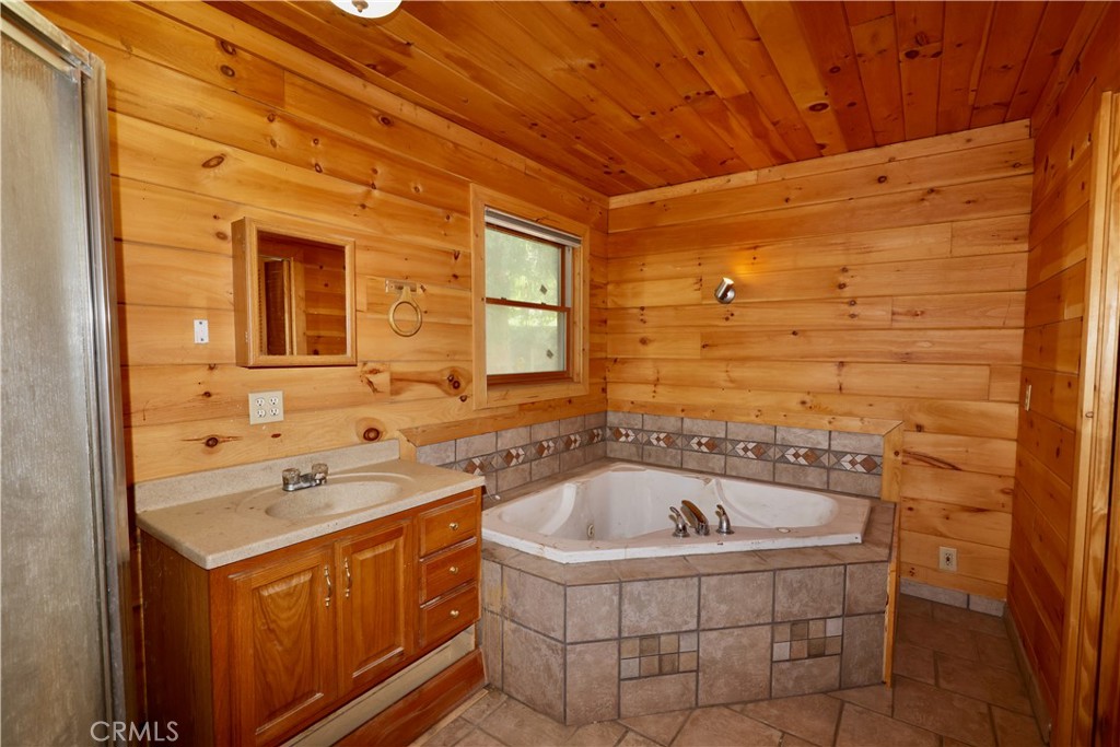 37023 Alder Drive Yucaipa, CA 92399 - Photo 22 of 34 a bathroom with a tub sink and mirror
