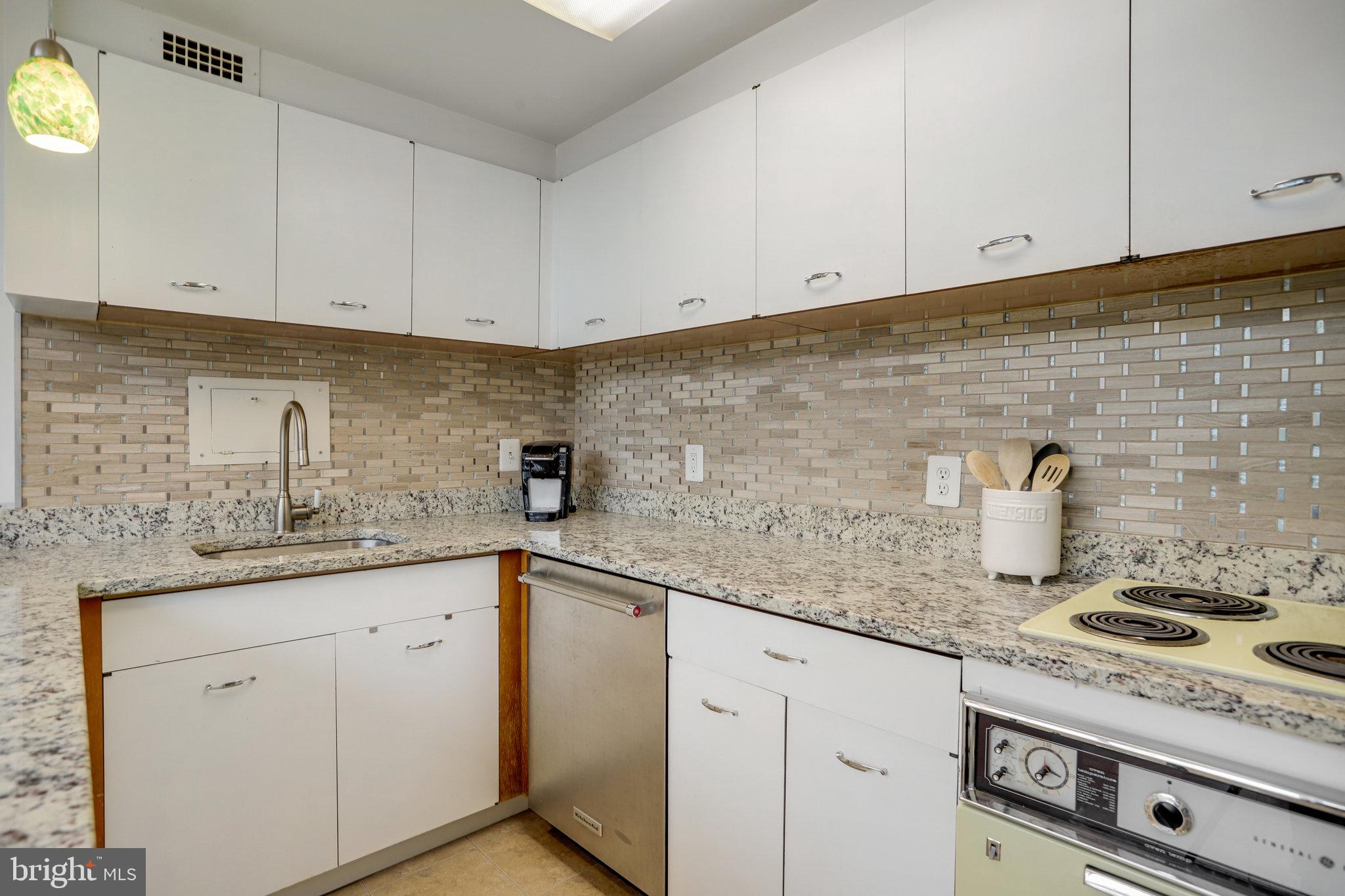 510 N Street Southwest, Unit N430 Washington, DC 20024 - Photo 9 of 29 a kitchen with granite countertop white cabinets and white appliances