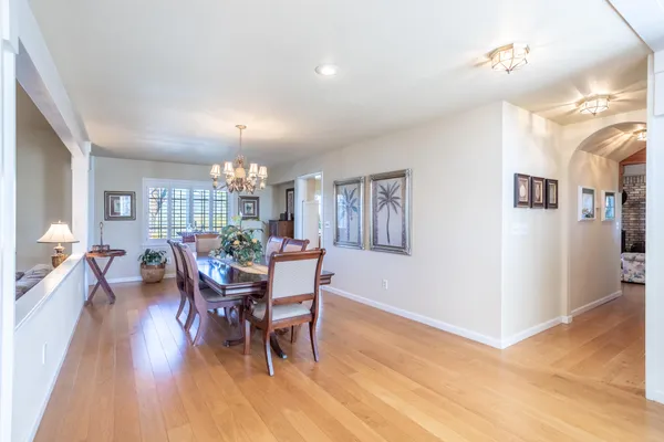 a dining room with furniture a chandelier and wooden floor