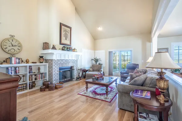 a living room with furniture a chandelier and wooden floor