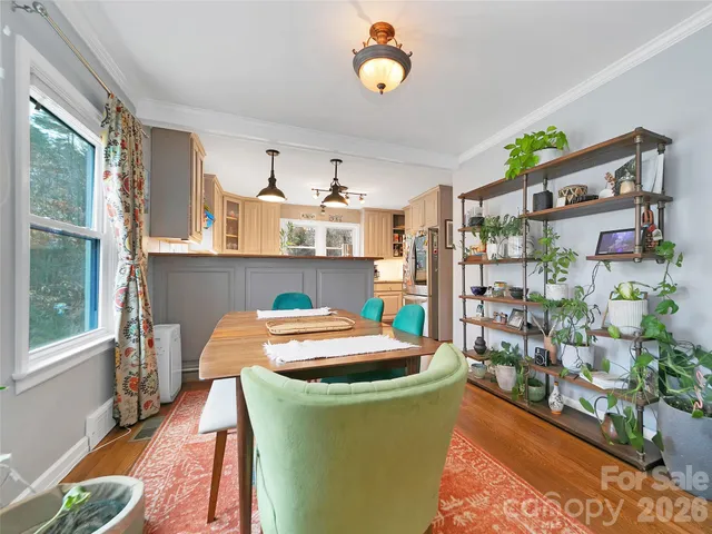 a dining room with furniture and a floor to ceiling window
