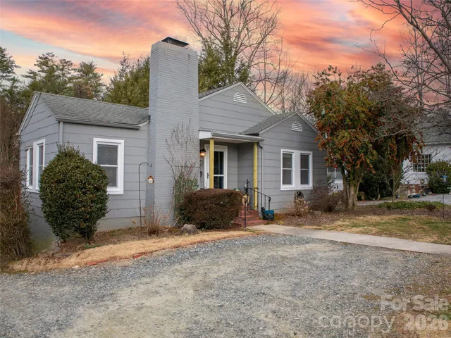 a view of a house with backyard and trees