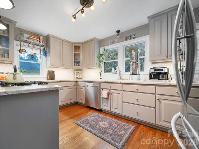 a kitchen with stainless steel appliances granite countertop a sink stove and cabinets