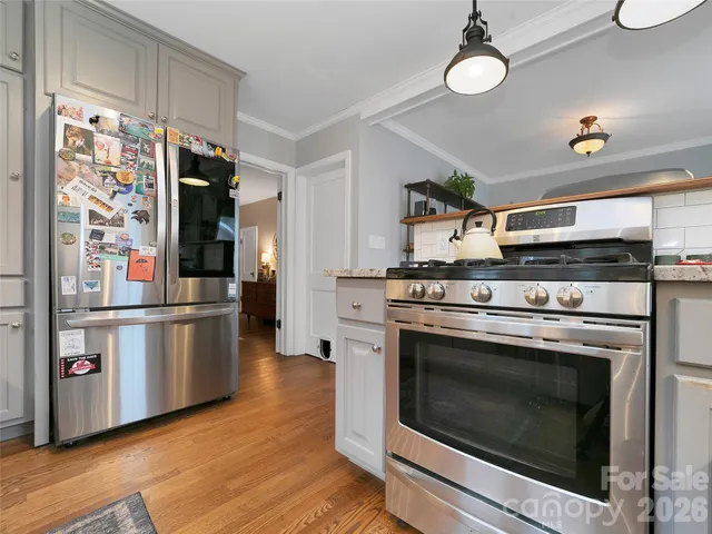 a kitchen with stainless steel appliances white cabinets a stove and a refrigerator
