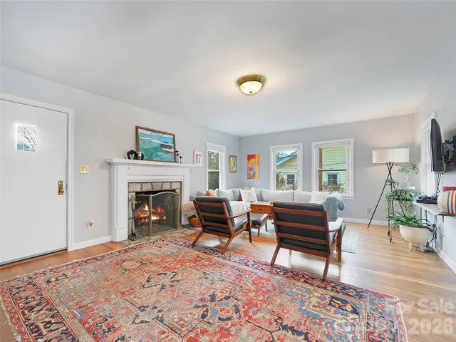 a living room with furniture a fireplace and a flat screen tv