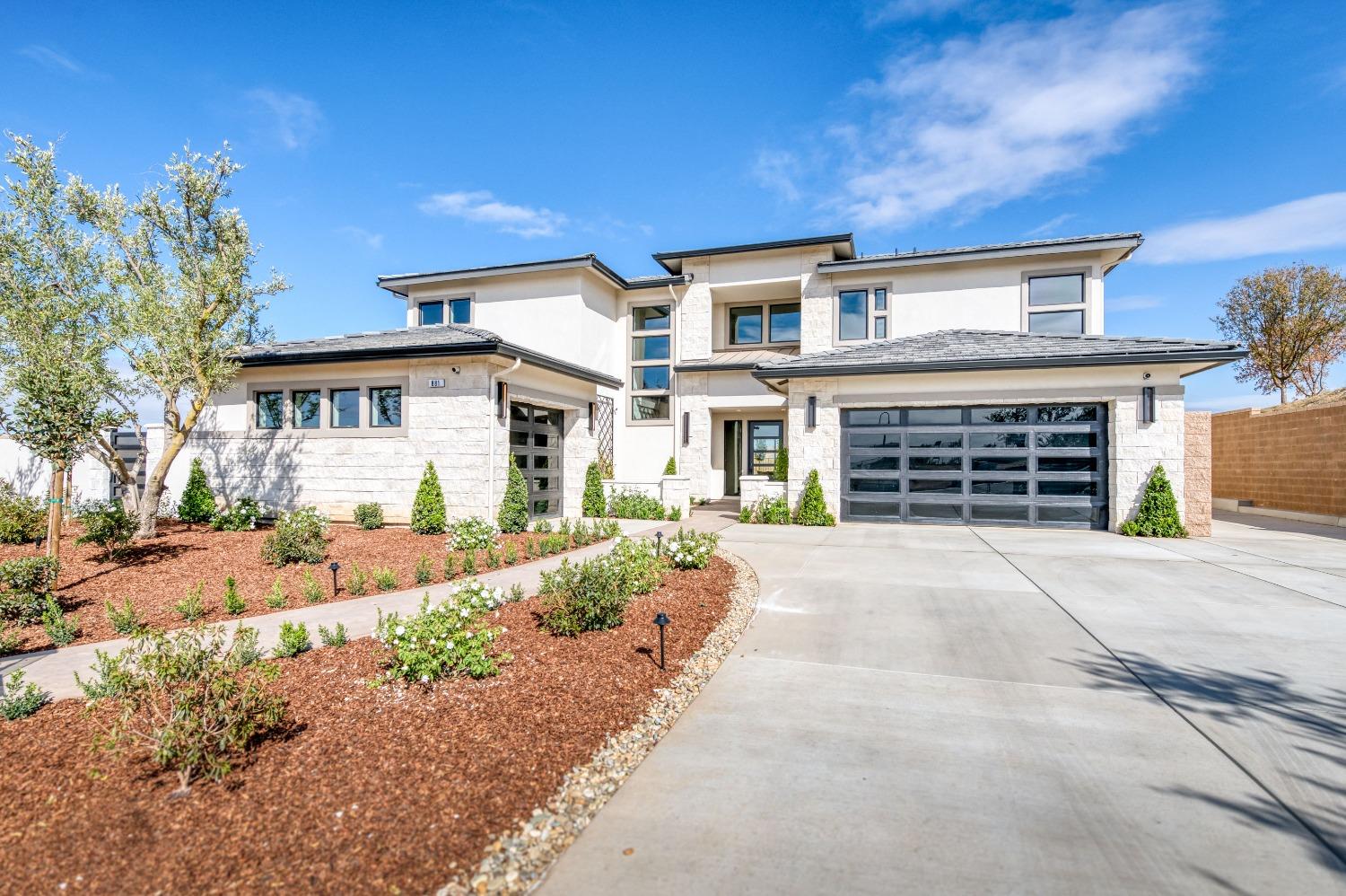 881 Terrace Place Madera, CA 93636 - Photo 11 of 85 a front view of a house with a yard and a garage
