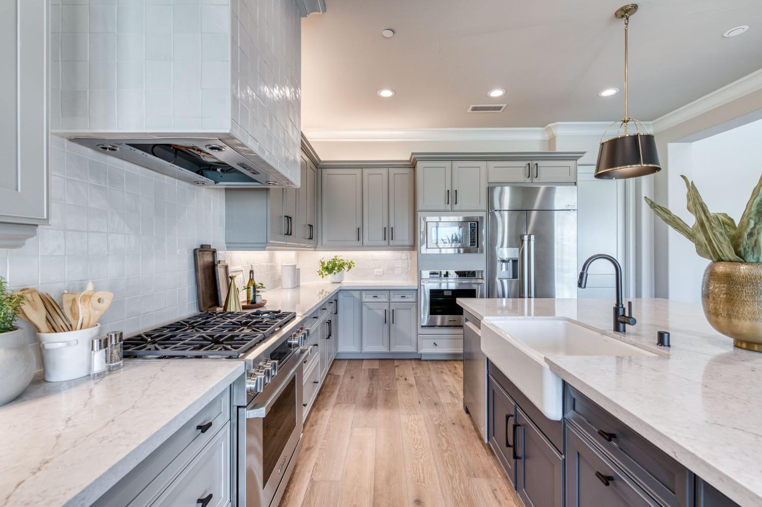 881 Terrace Place Madera, CA 93636 - Photo 21 of 85 a kitchen with stainless steel appliances a sink stove top oven and cabinets
