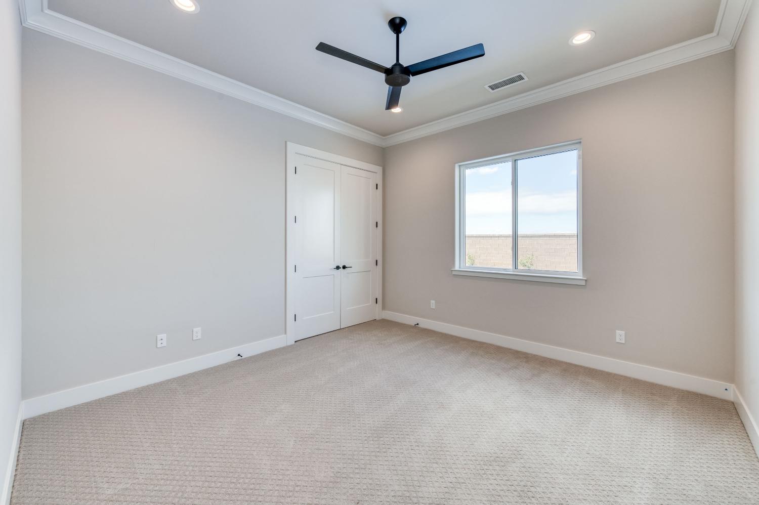 881 Terrace Place Madera, CA 93636 - Photo 30 of 85 an empty room with a ceiling fan and windows