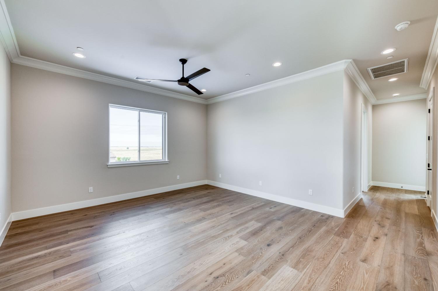 881 Terrace Place Madera, CA 93636 - Photo 35 of 85 a view of an empty room with wooden floor and a window