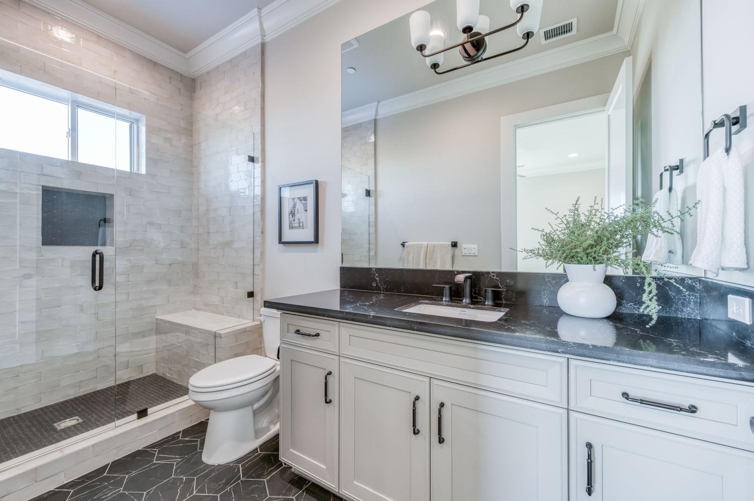 881 Terrace Place Madera, CA 93636 - Photo 37 of 85 a bathroom with a granite countertop sink a toilet a mirror and shower
