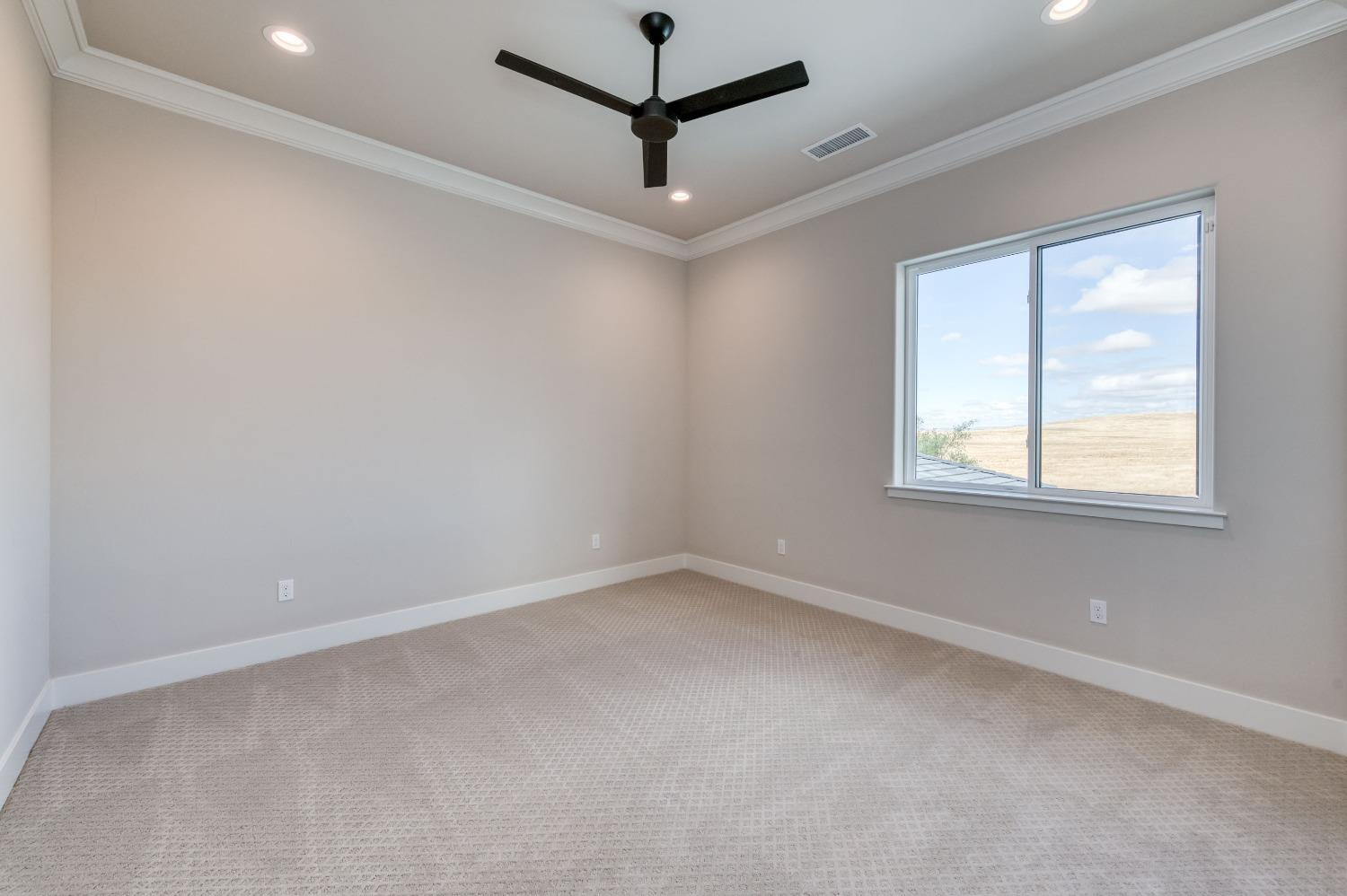 881 Terrace Place Madera, CA 93636 - Photo 38 of 85 an empty room with a window and a fan