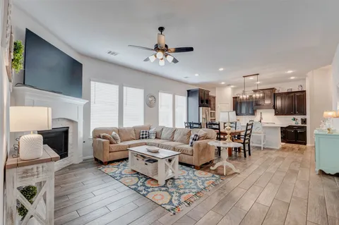a living room with fireplace furniture and a wooden floor