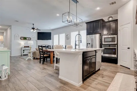 a kitchen with stainless steel appliances kitchen island a refrigerator and a stove top oven