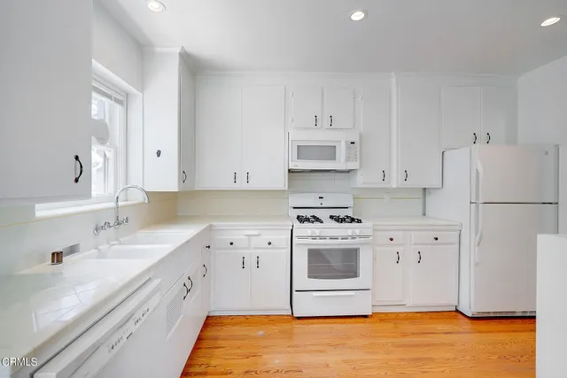 a kitchen with stainless steel appliances a stove a sink and a refrigerator