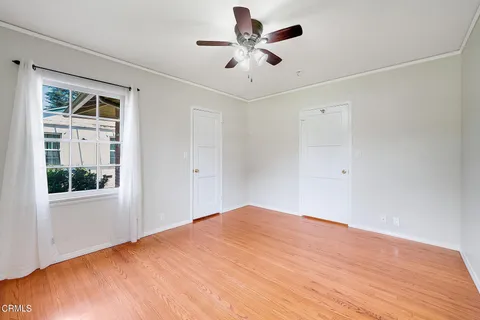 a view of a big room with wooden floor and a chandelier fan