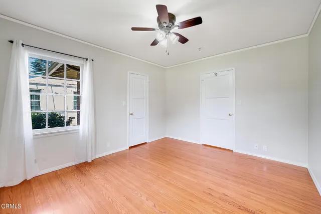 a view of a big room with wooden floor and a chandelier fan