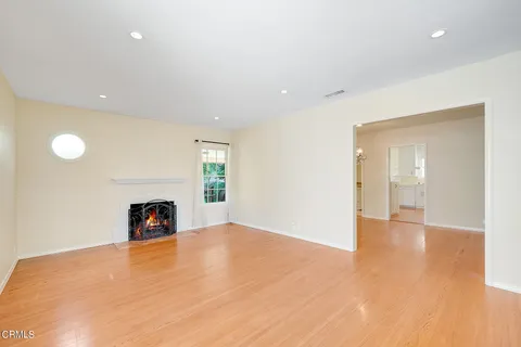 a view of an empty room with a fireplace and a window