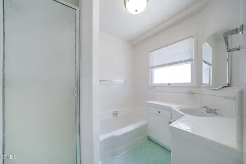 a bathroom with a bathtub sink and mirror