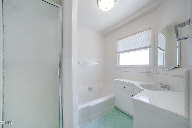 a bathroom with a bathtub sink and mirror