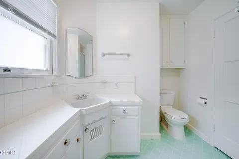 a bathroom with a sink toilet and a mirror