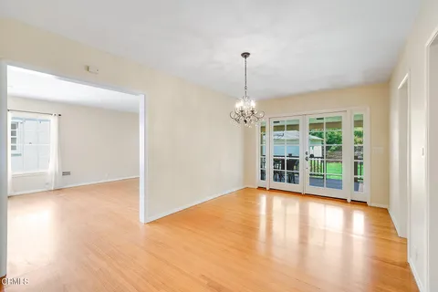 a view of a livingroom with wooden floor and a chandelier