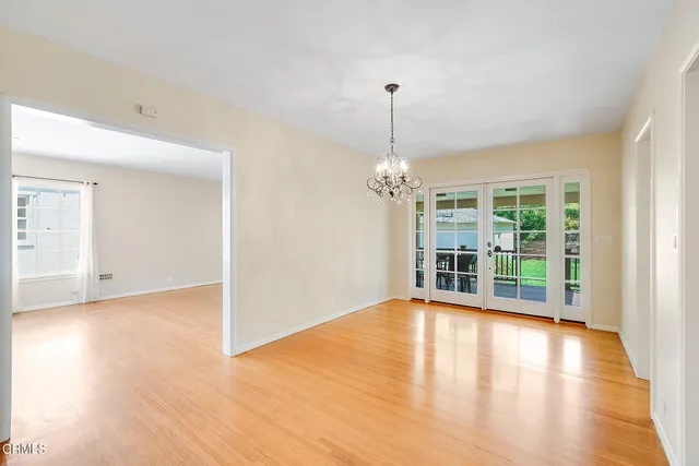 a view of a livingroom with wooden floor and a chandelier