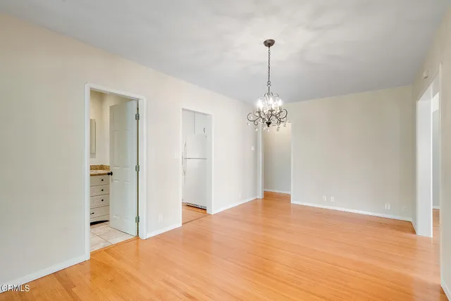 a bedroom with a chandelier and a dresser