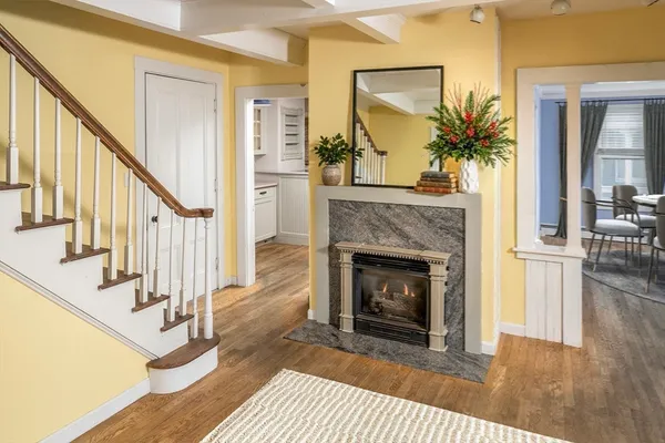 a view of a livingroom with fireplace wooden floor and staircase