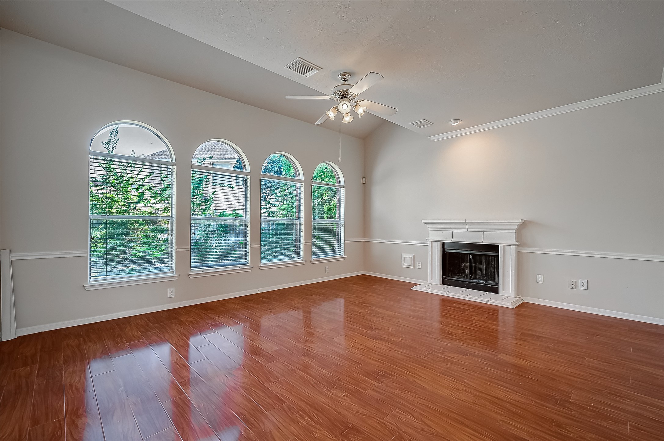 2907 Little Branch Court Houston, TX 77082 - Photo 11 of 50 an empty room with windows fireplace and wooden floor