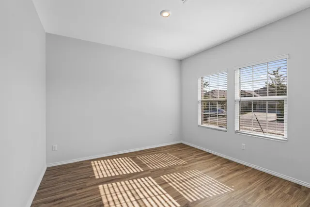 a view of a room with wooden floor and windows