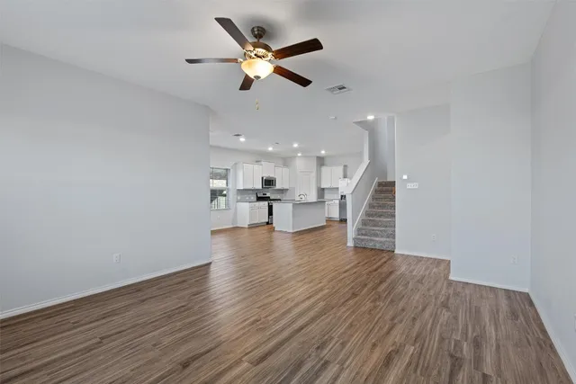 a view of kitchen with wooden floor and electronic appliances